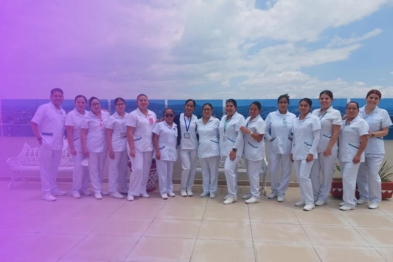Group of healthcare professionals in white uniforms standing together on a rooftop with ocean and sky in background
