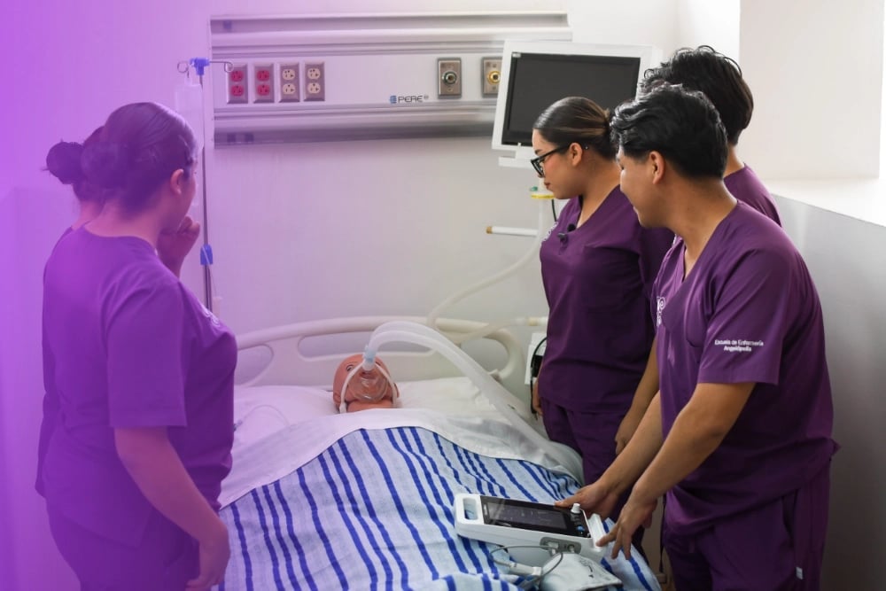 Medical professionals in purple scrubs examining a patient on a hospital bed during a clinical demonstration or training session
