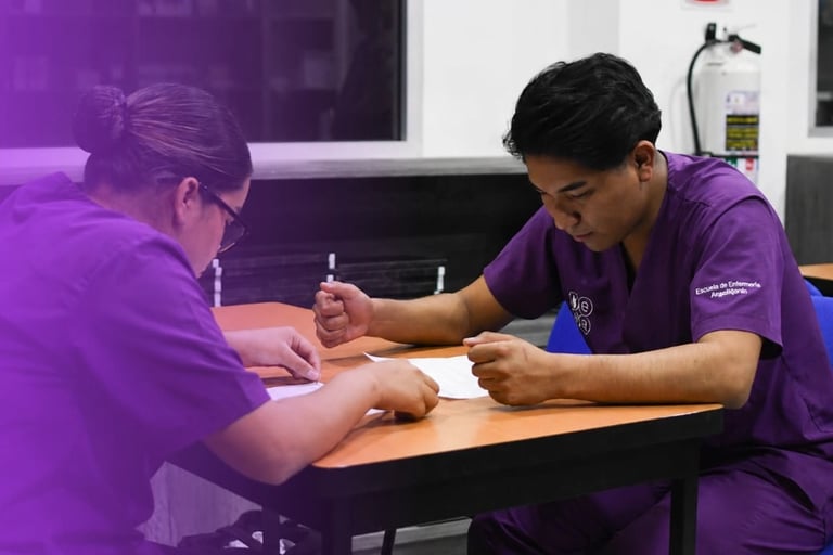 Two people in purple uniforms sitting at a table during a professional meeting or training session