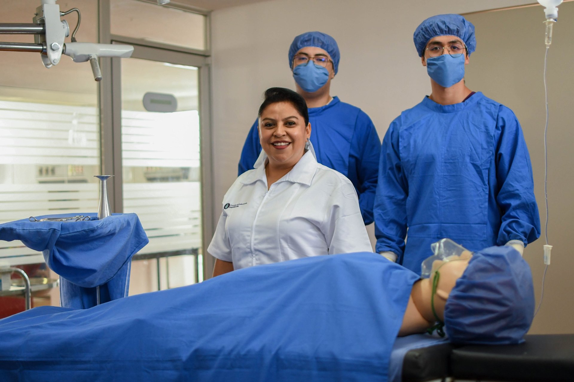 Medical team in surgical attire standing around an operating table in a hospital operating room